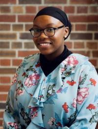 Picture of Emoni smiling in front of brick background