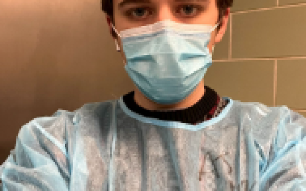 Picture of student in scrubs and mask
